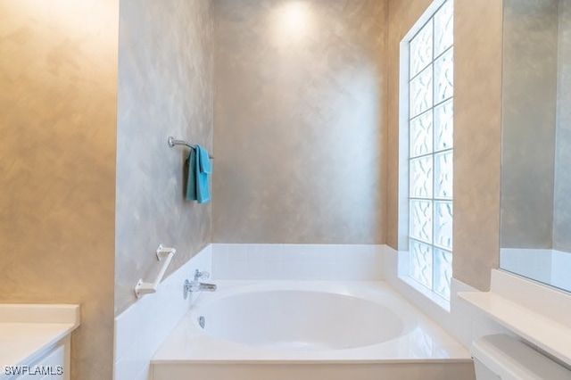 bathroom featuring a bathing tub, vanity, and toilet