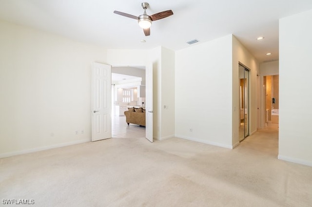 empty room with light colored carpet and ceiling fan