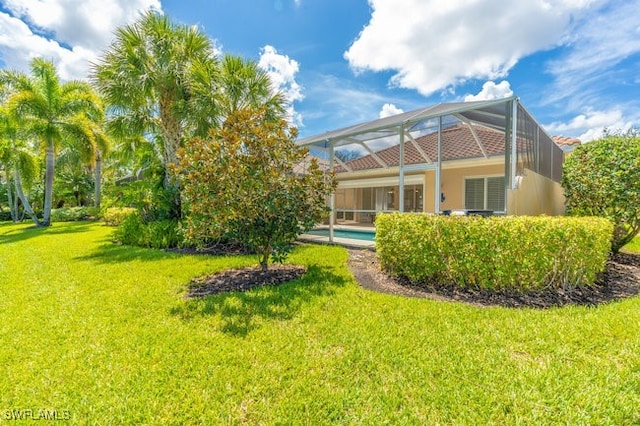 back of property with a lanai and a yard