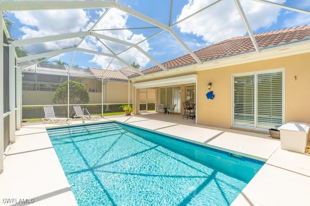 view of pool featuring glass enclosure and a patio