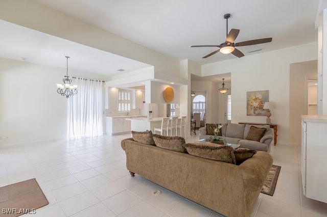 tiled living room featuring ceiling fan with notable chandelier