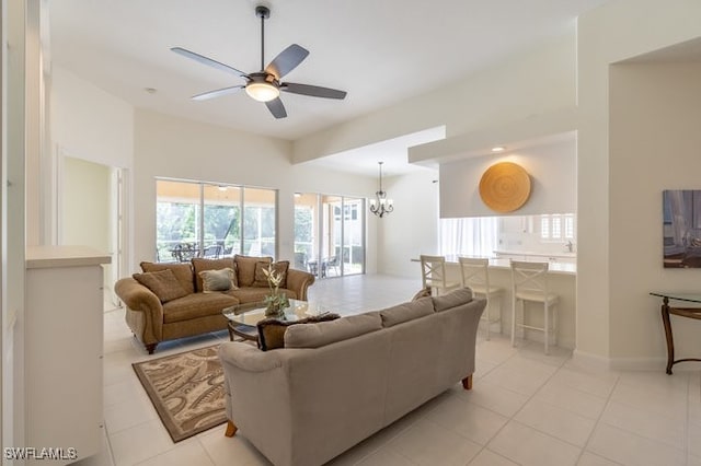 living room with light tile patterned floors and ceiling fan with notable chandelier