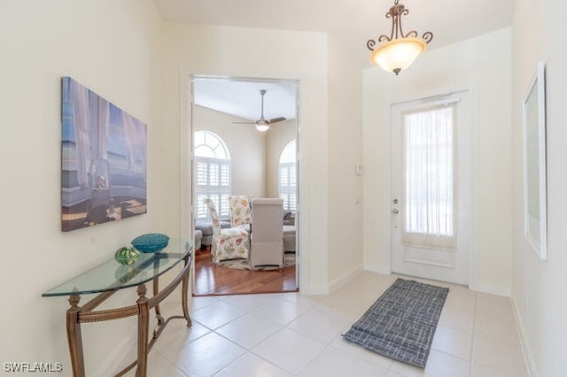 entryway with light tile patterned floors and ceiling fan