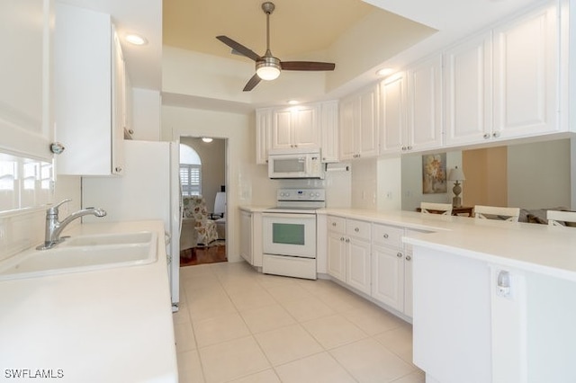 kitchen with plenty of natural light, white cabinets, and white appliances