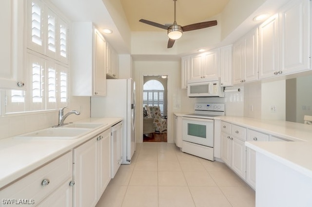 kitchen with white cabinets, white appliances, and plenty of natural light