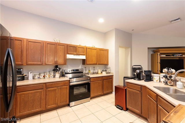 kitchen featuring black refrigerator, electric stove, sink, and light tile patterned floors