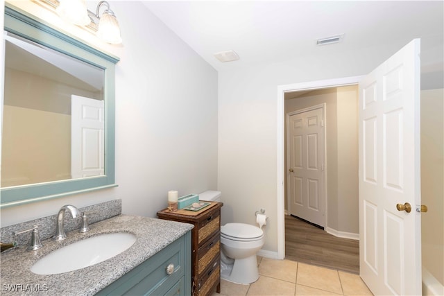 bathroom with wood-type flooring, vanity, and toilet