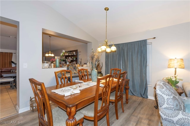 dining room featuring a chandelier, wood-type flooring, and vaulted ceiling