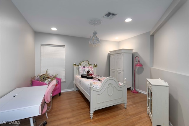 bedroom featuring light hardwood / wood-style floors and an inviting chandelier