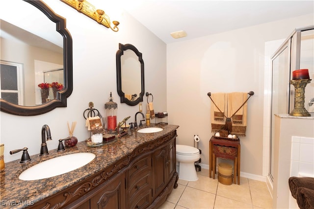 bathroom with tile patterned flooring, vanity, toilet, and a shower with door