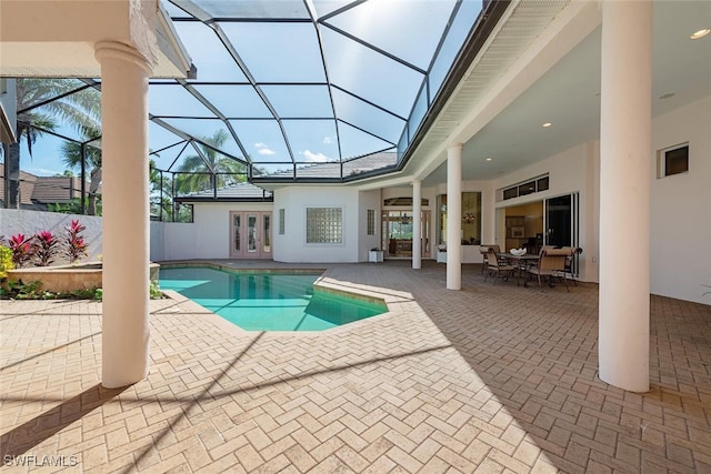 view of swimming pool featuring french doors, a patio area, and a lanai