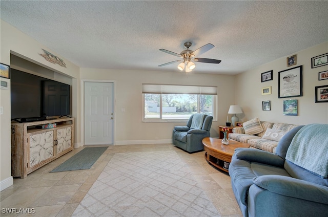 living room featuring ceiling fan and a textured ceiling