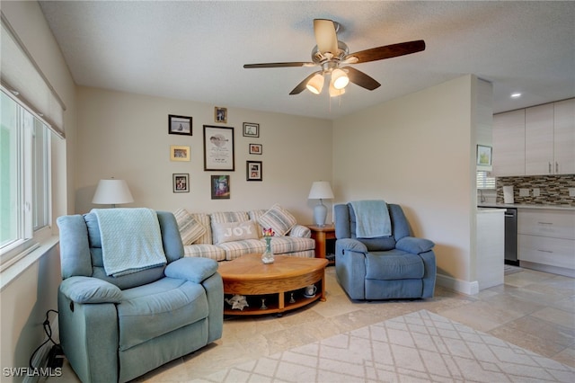 living room featuring a textured ceiling and ceiling fan