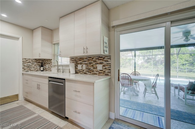 kitchen featuring backsplash, stainless steel dishwasher, ceiling fan, and sink