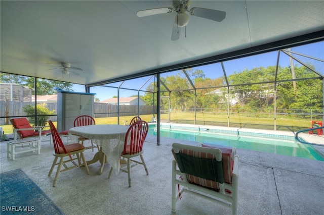 sunroom with ceiling fan, a wealth of natural light, and a swimming pool