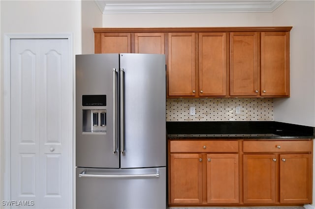 kitchen with decorative backsplash, stainless steel fridge with ice dispenser, dark stone counters, and ornamental molding