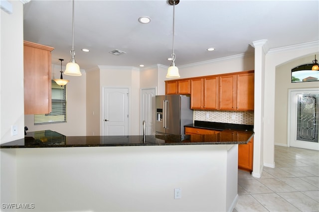 kitchen featuring kitchen peninsula, high end refrigerator, hanging light fixtures, and dark stone counters