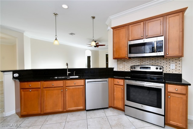 kitchen featuring ceiling fan, sink, hanging light fixtures, crown molding, and appliances with stainless steel finishes