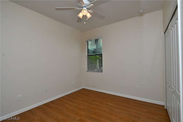 unfurnished bedroom with ceiling fan, a closet, and hardwood / wood-style flooring