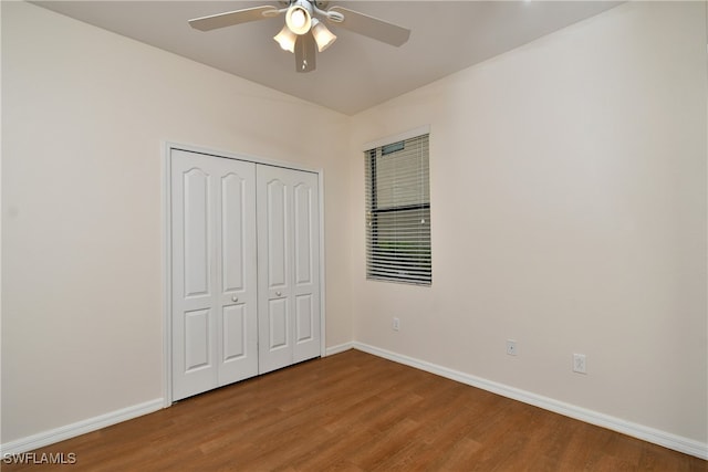 unfurnished bedroom with ceiling fan, a closet, and hardwood / wood-style flooring