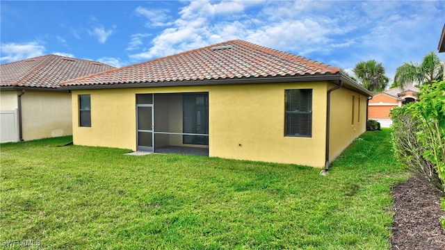 rear view of house featuring a yard