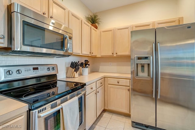 kitchen featuring light tile patterned floors, light brown cabinetry, appliances with stainless steel finishes, and tasteful backsplash