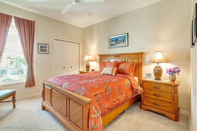 carpeted bedroom featuring ceiling fan and a closet