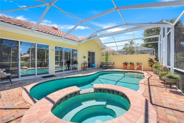 view of swimming pool featuring an in ground hot tub, glass enclosure, and a patio area