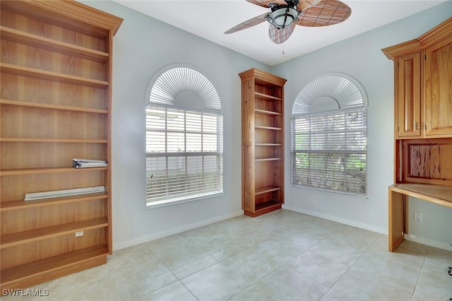 unfurnished dining area with ceiling fan and light tile patterned flooring