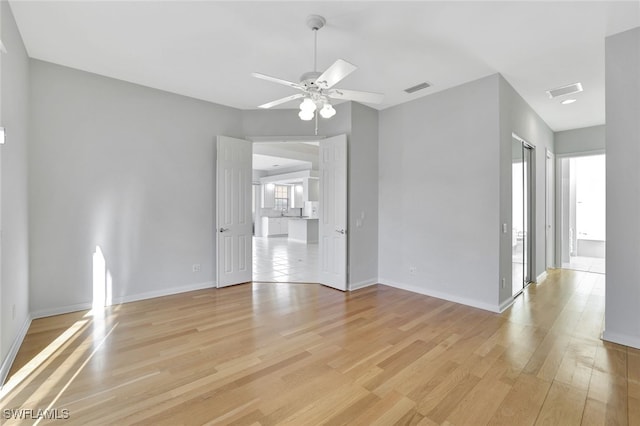 spare room with ceiling fan, a healthy amount of sunlight, and light wood-type flooring