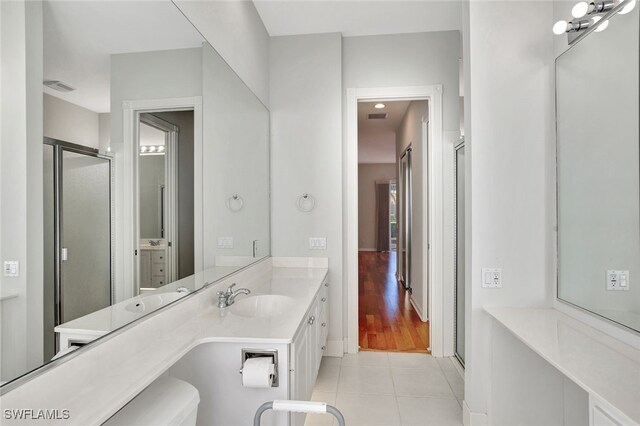 bathroom with tile patterned flooring, vanity, and an enclosed shower