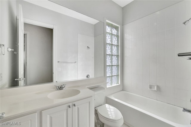 full bathroom with tiled shower / bath, vanity, and toilet