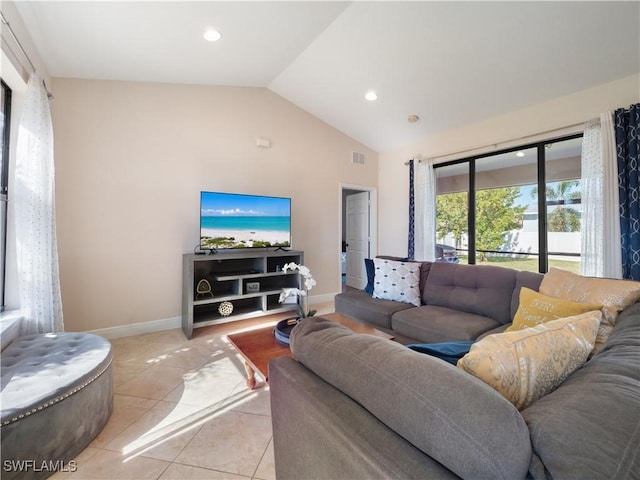 living room with light tile patterned floors and vaulted ceiling