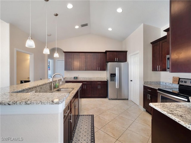 kitchen featuring an island with sink, sink, hanging light fixtures, light stone counters, and stainless steel appliances