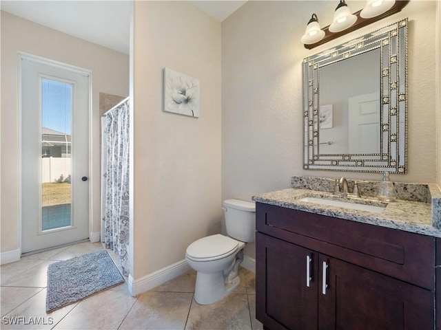 bathroom featuring walk in shower, vanity, toilet, and tile patterned flooring