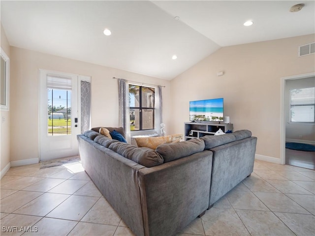 tiled living room featuring plenty of natural light and lofted ceiling