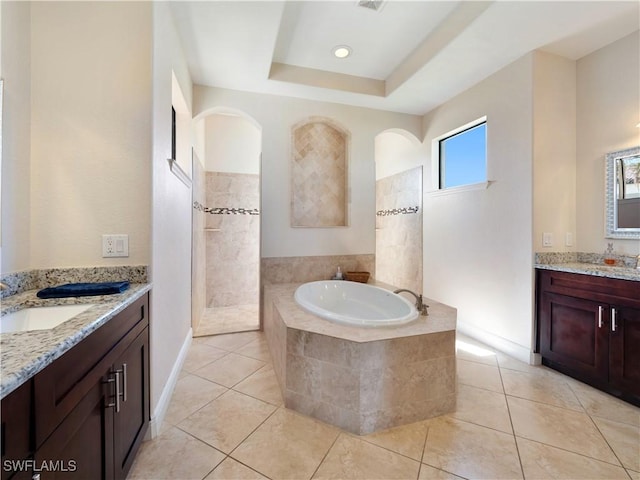 bathroom with tile patterned flooring, vanity, independent shower and bath, and a tray ceiling