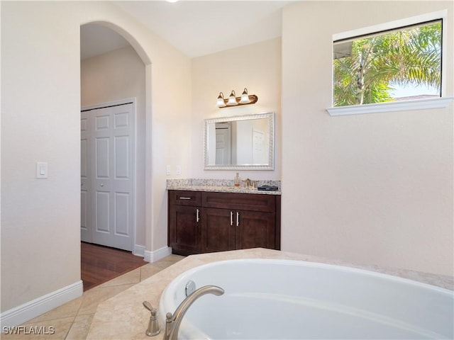 bathroom featuring vanity, tiled tub, and tile patterned floors