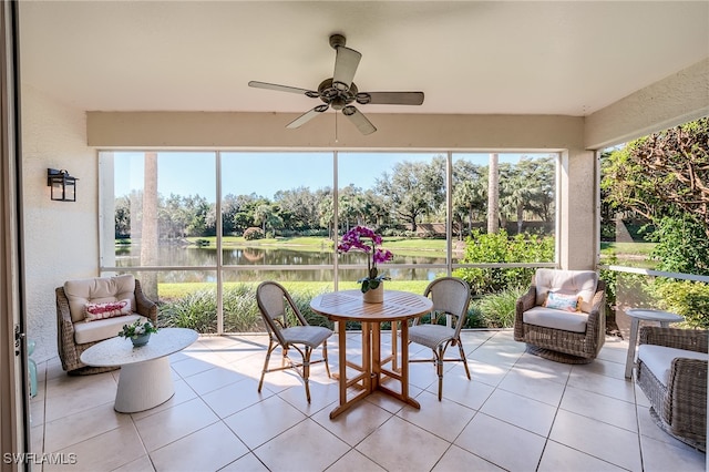 sunroom / solarium with a wealth of natural light, a water view, and ceiling fan