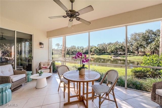 sunroom / solarium with ceiling fan and a water view