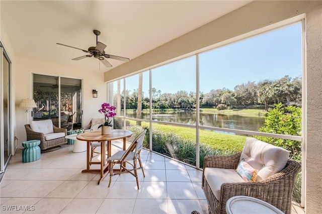 sunroom featuring ceiling fan and a water view