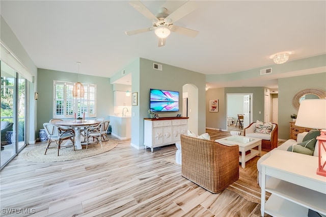 living room featuring ceiling fan, light wood-type flooring, and sink