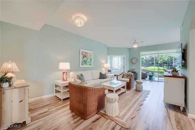 living room with light hardwood / wood-style flooring and ceiling fan