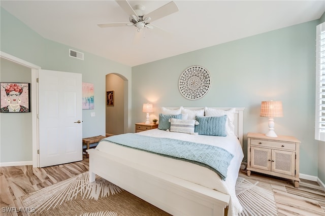 bedroom with multiple windows, light hardwood / wood-style floors, and ceiling fan