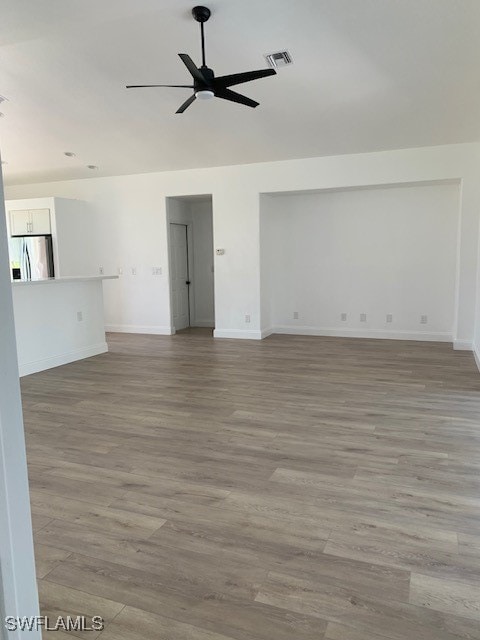 empty room with ceiling fan and light wood-type flooring