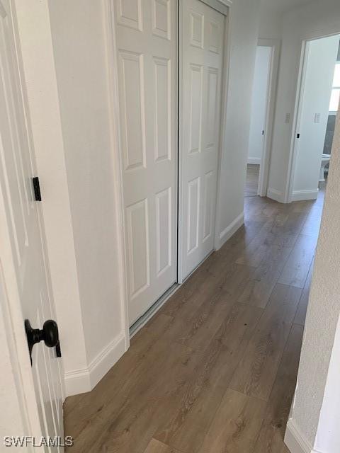 3026 SW 24th Ave, Cape Coral, FL 33914 - hallway featuring wood finished floors and baseboards