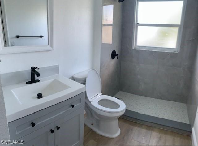 3026 SW 24th Ave, Cape Coral, FL 33914 - full bath featuring vanity, a tile shower, toilet, and wood finished floors