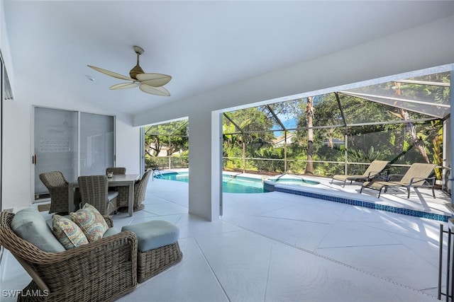 view of patio / terrace with ceiling fan, a swimming pool with hot tub, and a lanai