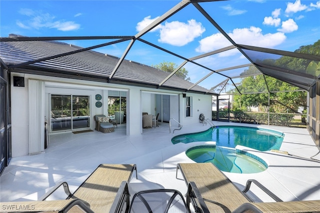 view of swimming pool with glass enclosure, a patio area, and an in ground hot tub