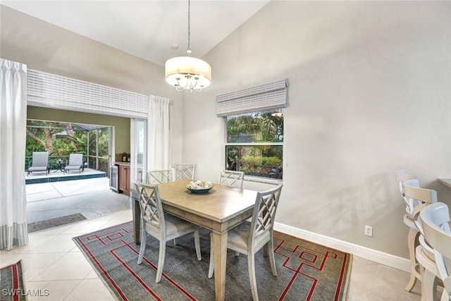 dining area with a wealth of natural light, light tile patterned flooring, vaulted ceiling, and a notable chandelier